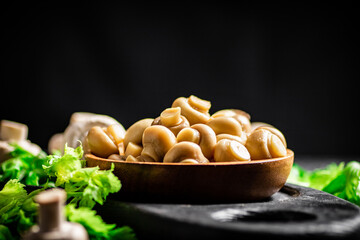 Fragrant pickled mushrooms in a plate with greens. 