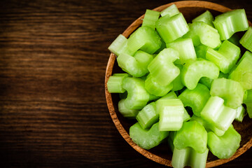 A wooden plate with a piece of celery. 