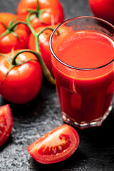 Fresh tomato juice. On a black background.
