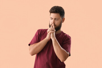 Thoughtful young bearded man on beige background