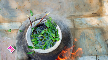 Green Neem leaves known as Azadirachta indica boiled in water on chulha. Boiling neem, nimtree or...