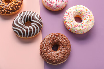 Delicious glazed donuts on color background