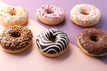 Delicious glazed donuts on color background
