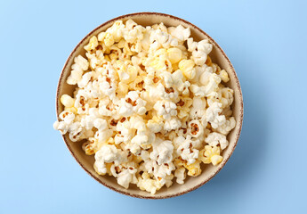 Bowl full of tasty popcorn on color background
