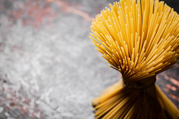 Not cooked spaghetti dry. Against a dark background.