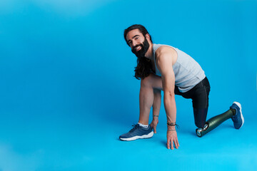 Smiley man with a leg prosthesis in sprinting position