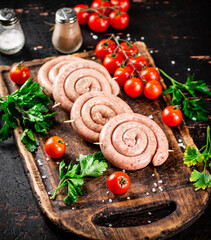 Round raw sausages with tomatoes and parsley. 