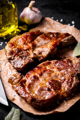Grilled pork steak on paper on the table. 