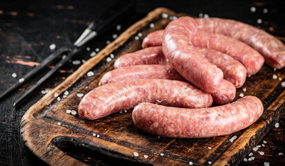 Raw sausages on a cutting board. 