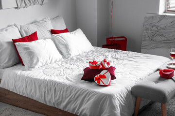 Interior of light bedroom decorated for Valentine's Day with gifts