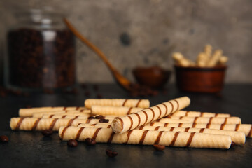 Heap of tasty wafer rolls on dark grunge table