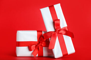 Gift boxes with beautiful bows on red background. Valentine's Day celebration