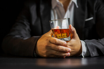 Closeup businessmen holding a glass of whiskey