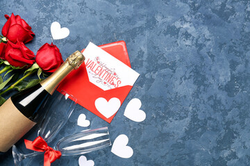Bottle of wine, rose flowers, envelope and paper hearts on blue table. Valentine's Day celebration