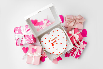 Box with heart-shaped bento cake, gifts and hearts isolated on white background. Valentine's Day celebration