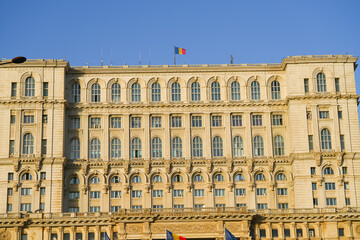 Fototapeta premium he Romanian flag waving on the Parliament Palace on a sunny day.