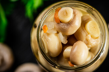 An open jar of homemade pickled mushrooms. 