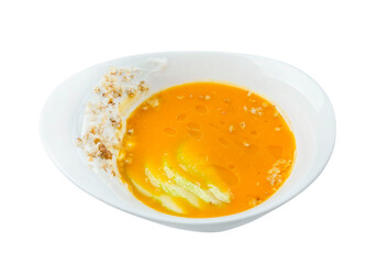 Pumpkin soup puree in a white plate. Appetizing traditional autumn dish. Top view. Isolated on white background.