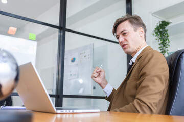 handsome businessman using laptop working at office. male working browsing data online in corporate. meeting businessperson online workplace.