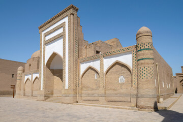 Fototapeta na wymiar The building of the ancient Muhammad Amin Inak madrasah close-up on a sunny day. Khiva, Uzbekistan