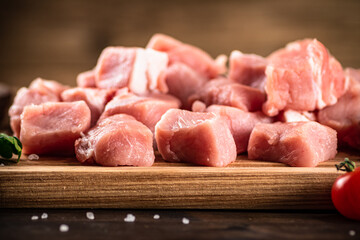 Pieces of raw pork on a cutting board.