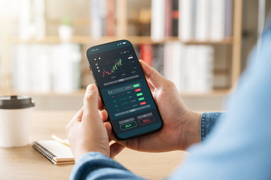 Concept of value investor and trader, businessman using smart phone application to invest in stock market, technical price charts and indicators, global stock and asset investment.