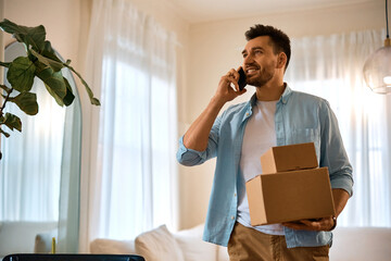 Happy man talks on cell phone after receiving home delivery.