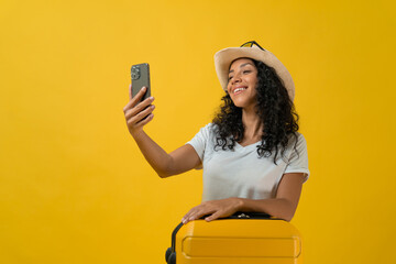 Happy Traveler curly latin woman wears white t-shirt with suitcase bag  take a selfie by smartphone...