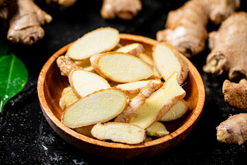 Pieces of fresh ginger root in a wooden plate. 