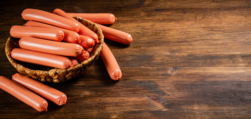 Delicious boiled sausages in a basket on the table. 