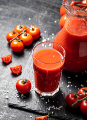 Tomato juice on a stone board with pieces of salt. 