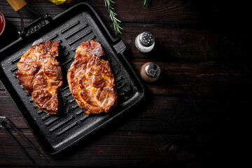 Grilled pork steak in a frying pan. 