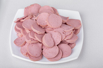 Top down view of sliced sausage into small pieces on white plate. Ingredients. Selective Focus 