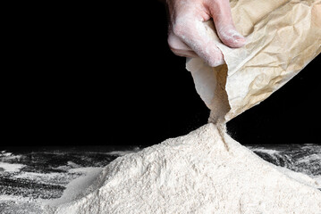 Baker pouring flour on table. Preparing dough for bread or pizza.