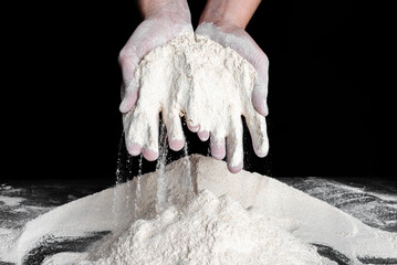 Baker with flour in hands. Preparing whole grain flour for bread. Baking concept.