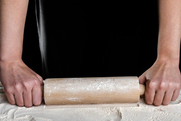 Baker with rolling pin on flour. Baking bread concept.