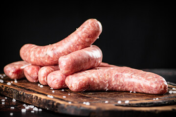 Raw sausages on a cutting board. 