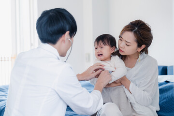 家を訪問したドクターに診てもらう赤ちゃん