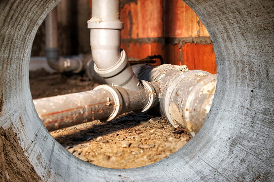 Sewer pipes in home basement. System of gray sanitary pipes when building a house. Sewer installation for sewage disposal.