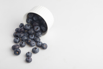 blueberries in a cup on a white background