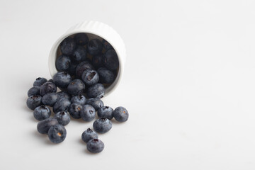 blueberries in a cup on a white background