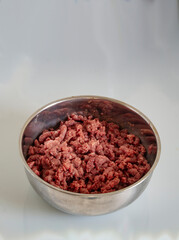 minced meat in a metal bowl, the process of preparing bolognese sauce