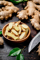 Pieces of fresh ginger on a wooden plate. 
