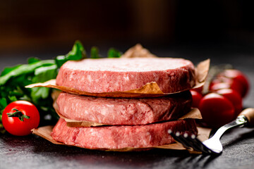 Raw burger with tomatoes and parsley. 