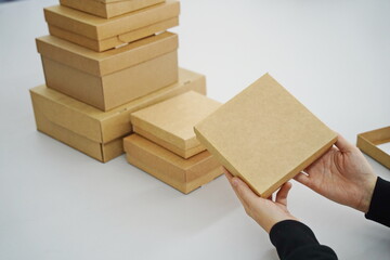 A woman holds cardboard boxes for parcels and delivery