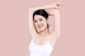 Beautiful young Asian woman lifting hand up to shows off clean and clear armpit or underarms isolated on pink background, Smooth and freshness armpit concept. - obrazy, fototapety, plakaty