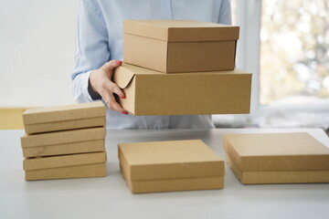 A woman holds cardboard boxes for parcels and delivery