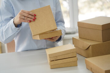 A woman holds cardboard boxes for parcels and delivery