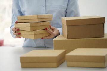 A woman holds cardboard boxes for parcels and delivery