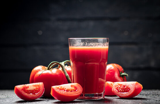 Fresh tomato juice. On a black background.